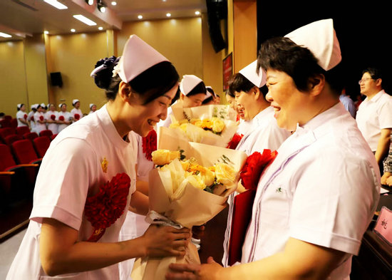 南阳市中医院召开2025年“5·12”国际护士节表彰大会_fororder_向受表彰者献上鲜花 摄影 高嵩