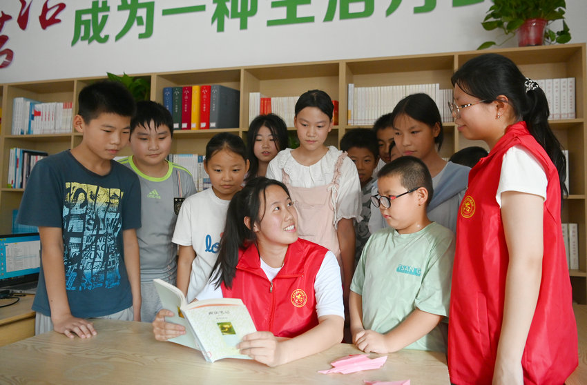 信阳市新县：书香伴暑假 阅读润童心_fororder_大学生志愿者领着孩子们感受阅读乐趣（焦汉平 摄）