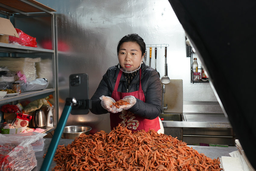 信阳​新县：电商打开新销路 “土特产”变“金招牌”_fororder_卢娇娇正在直播销售红薯干（曾亚芳 摄）