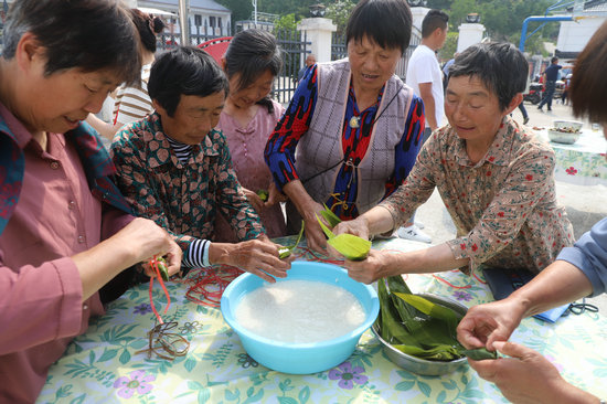 信阳市商城县：清塘坳里吹来文明乡风_fororder_包粽子比赛 洪晓燕 摄.JPG
