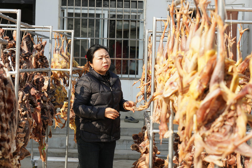 信阳​新县：电商打开新销路 “土特产”变“金招牌”_fororder_卢娇娇在翻晒腊味（ 曾亚芳 摄）