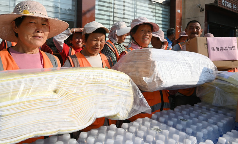 信阳市新县：夏日送清凉 关怀暖人心_fororder_领取毛巾、矿泉水等物品（焦汉平 摄）