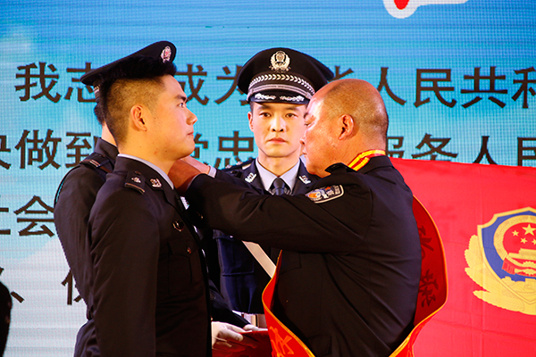 宜宾高县举行“首届中国人民警察节”主题庆祝大会_fororder_退休民警为新警代表佩戴肩章-摄影-高学兵6