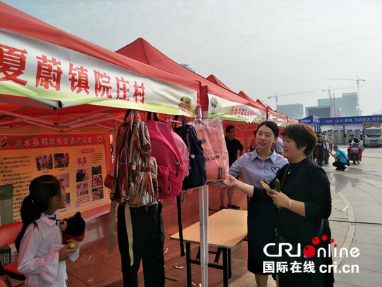 临沂市沂水县夏蔚镇农副产品促增收_fororder_夏蔚镇工作人员在向顾客介绍产品 周少华 摄影