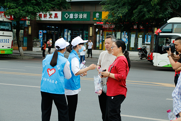 宜宾：学子快乐高考 社会暖心服务_fororder_志愿者为送考家长送上矿泉水-摄影-高学兵