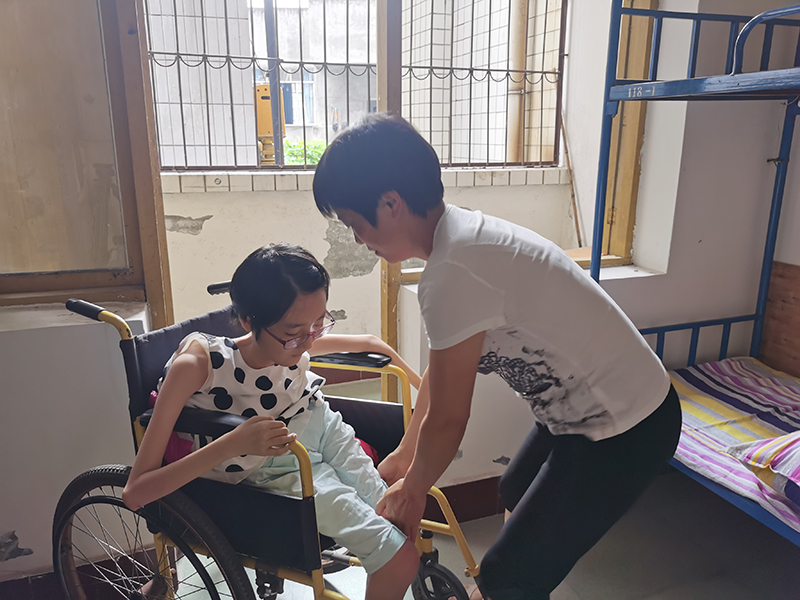 谭伍越：“不普通”的身体拥有超越平凡的力量 高考成绩优异努力奔向未来_fororder_母亲正在照顾谭伍越-摄影-潘建勇
