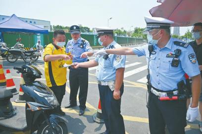 战高温防疫情 成都公安在行动_fororder_成都交警四分局民警对进入疫情防控核心区域的外卖人员进行登记