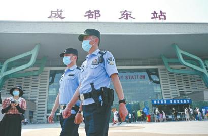 战高温防疫情 成都公安在行动_fororder_民警郑学强（右）和同事一起在成都东站西广场上巡逻
