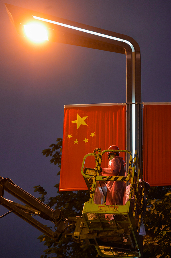 挂国旗迎国庆 “中国红”闪耀成都街头_fororder_作业人员夜晚悬挂国旗-供图-成都市城管委