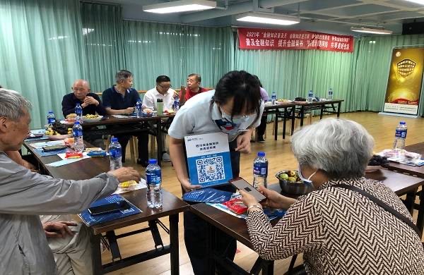 普及金融知识 浦发银行成都分行开展金融知识进社区活动_fororder_工作人员为老年人讲解电信诈骗案例