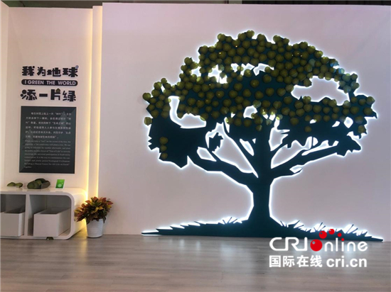 腊肠树、蒜头果、五色米……探访云南生物多样性保护实践与成果展_fororder_△“我为地球添一片绿”展位——每在树冠上贴一片“树叶”，主办方就会种下一棵树。会后通过统计“树叶”数量，将共同种下“生命之树”公益林。