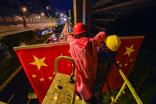 挂国旗迎国庆 “中国红”闪耀成都街头_fororder_悬挂国旗现场-供图-成都市城管委
