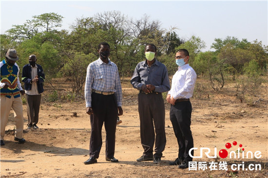 （中非合作论坛）1000口“中国井”扎根津巴布韦 润泽40万民众_fororder_段传秀（右一）与打井项目受惠的村民交谈
