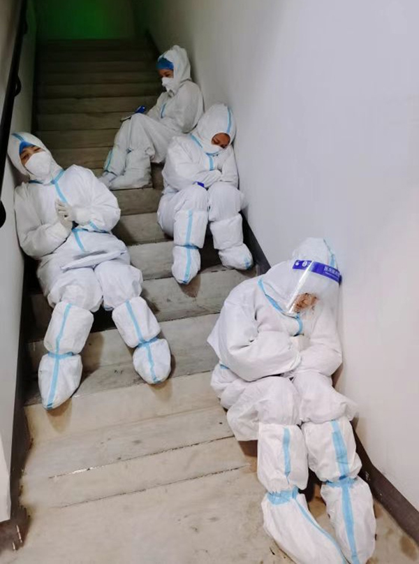 招募不到一小时 成都温江区疫情防控青年突击队组建完毕_fororder_穿着防护服的社区工作人员在深夜工作间隙席地而睡-供图-温江区融媒体中心
