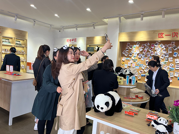 成都彭州首家“熊猫邮局”正式营业 开启游客“漫邮时光”_fororder_游客和YOYO合影-摄影-张鸿