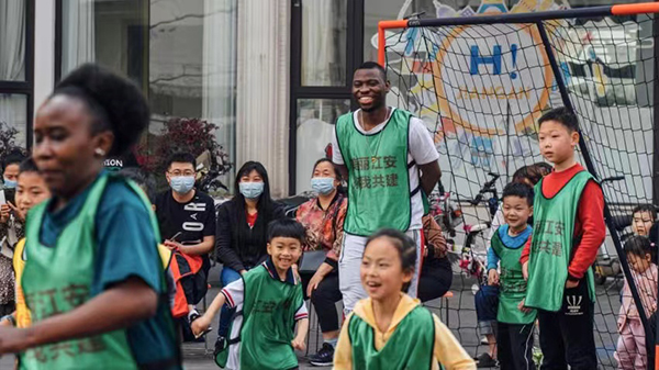 老外在四川｜马里留学生巴雷：我为成都大运会加油_fororder_巴雷和小朋友们参加足球活动-受访者供图