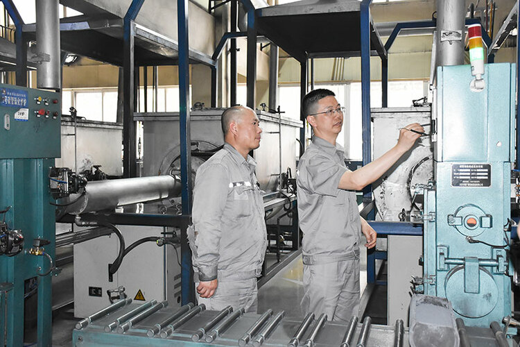 四川自贡：工艺设备行业典范 潘登荣获全国五一劳动奖章称号_fororder_潘登（右）向一线操作员交流设备使用情况（摄影-赵丽）