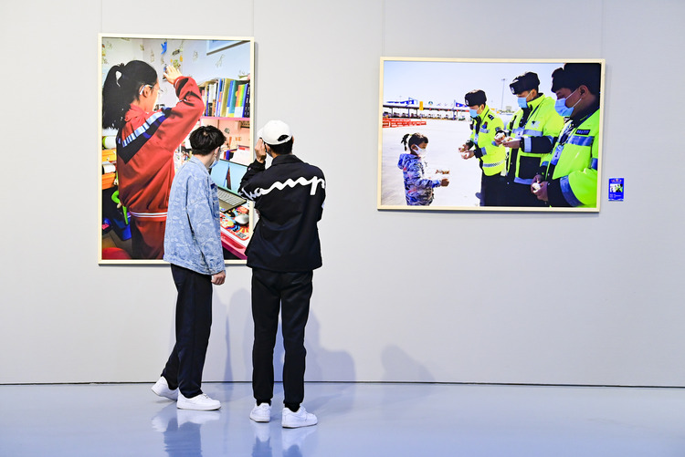 内蒙古：呼和浩特抗击疫情摄影作品展开展_fororder_（6）2022年4月29日，观众在内蒙古美术馆观赏抗击疫情摄影作品展。.JPG