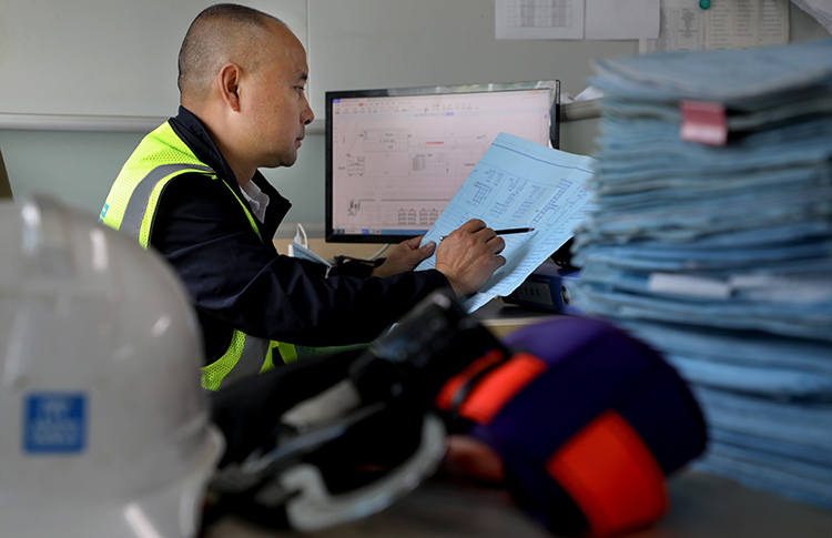 中国梦 劳动美｜罗登华：空中造楼操盘手 精益求精的建筑工_fororder_（19）《筑梦新时代---定格劳动美》系列报道——五·一奖章获得者罗登华---图为-罗登华机电工长一丝不苟的对每一次空中造楼机的顶升工程都要做周密研究，对图纸上每一个数字认真核对，始终坚持学习，这就是他成为正真的工匠奋斗目标。摄影张全能----电话13982193095(16)