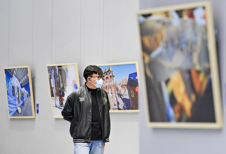 内蒙古：呼和浩特抗击疫情摄影作品展开展_fororder_（8）2022年4月29日，观众在内蒙古美术馆观赏抗击疫情摄影作品展。.JPG