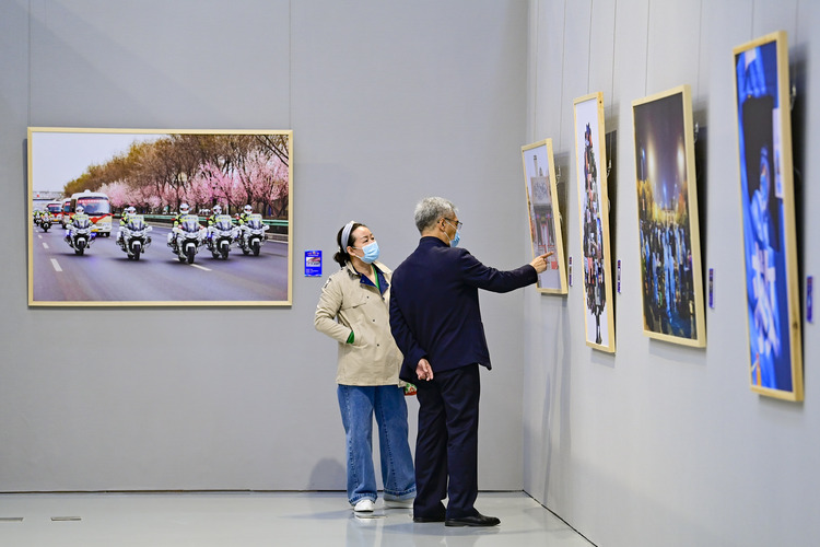 内蒙古：呼和浩特抗击疫情摄影作品展开展_fororder_（4）2022年4月29日，观众在内蒙古美术馆观赏抗击疫情摄影作品展。.JPG