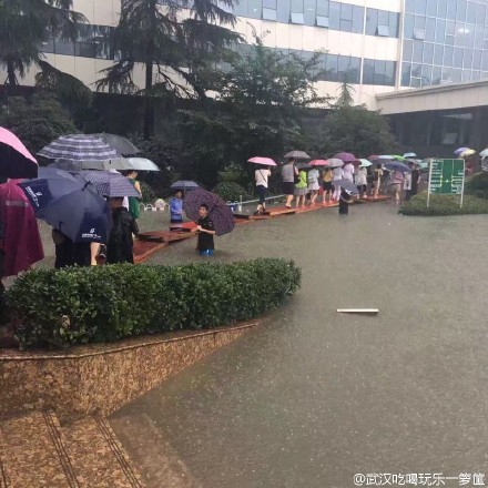 暴雨中的前行者 致敬“武汉人的上班精神”(组图)-国际在线