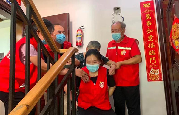 最美“志愿红” 织密简阳社区“防护网”_fororder_邓红梅把老人背下楼去医院接种疫苗-供图-简阳市委宣传部