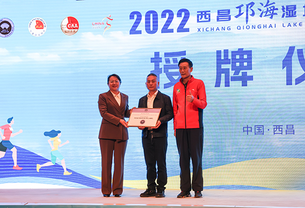 2022西昌邛海湿地马拉松赛将于12月11日鸣枪开跑_fororder_四川省田径协会主席李健代表世界田联向凉山州人民政府副州长周仕伦、西昌市人民政府市长宋莉授西马精英标牌。