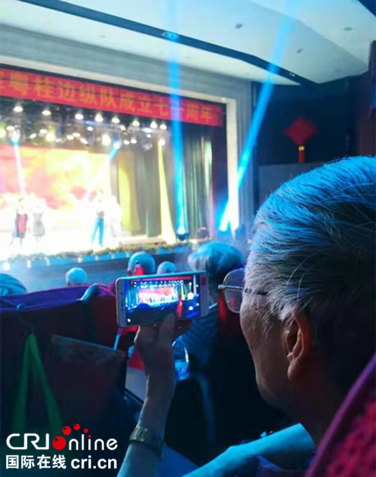 图片默认标题_fororder_老战士用手机记录精彩的演出。摄影陈惠婷
