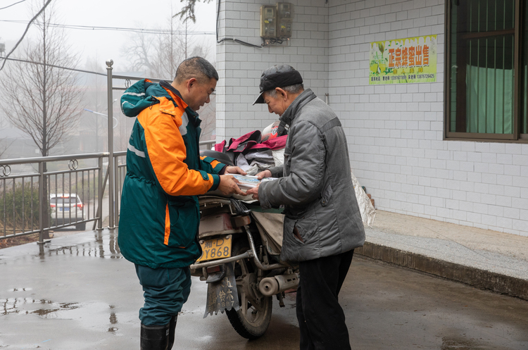 杨桢桂：穿行在南岳衡山的“云端信使”_fororder_老杨把报刊杂志送到寿岳乡岳林村曹云翔家。莫雄飞摄