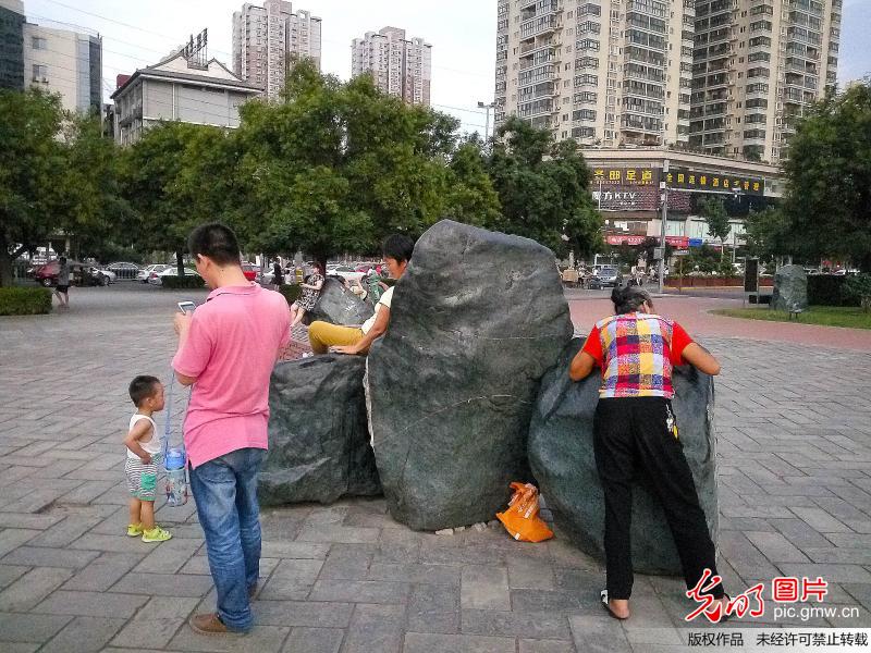 西安大妈们趴石头上"热疗" 晚了排不上队