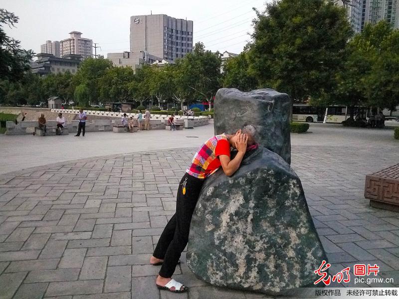 西安大妈们趴石头上"热疗" 晚了排不上队