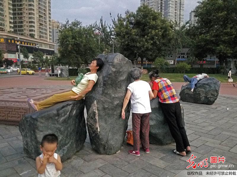 西安大妈们趴石头上"热疗" 晚了排不上队