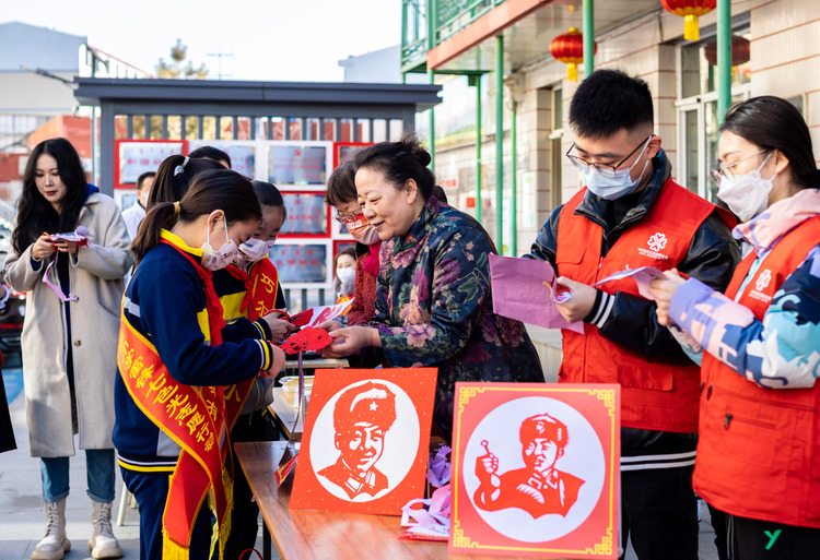 呼和浩特市玉泉区：寻雷锋足迹 扬志愿精神_fororder_1——2023年3月3日，呼和浩特市玉泉区清泉街社区志愿者，非遗剪纸传承人董存娥（ 右三）在教孩子们创作“雷锋”剪纸作品。20230303-A01I3210