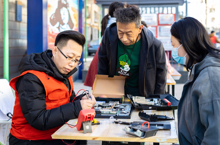 呼和浩特市玉泉区：寻雷锋足迹 扬志愿精神_fororder_7——2023年3月3日，呼和浩特市玉泉区清泉街社区志愿者为社区居民免费维修电脑。20230303-A01I3227