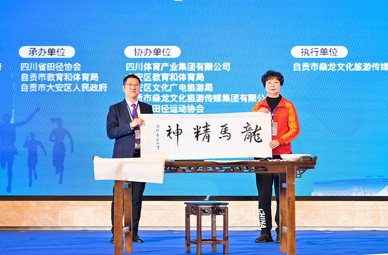 融体育锻炼与休闲快乐于一体的全民盛会 自贡恐龙半程马拉松即将鸣枪开跑_fororder_3自贡籍世界冠军、形象大使童玲向大安区赠送书法作品（摄影-廖志全）