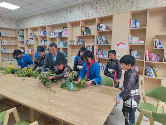 （供稿）贵州施秉：“农家书屋+”模式 打造精神粮仓_fororder_六合村农家书屋图书管理员潘春仁正在教授学生利用本地植物插花，装扮书屋