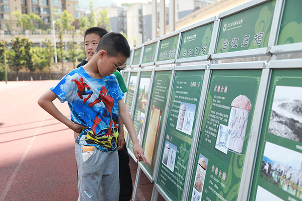 （张）泸州合江：博物馆动起来 活起来_fororder_同学们驻足观看宋代画像石刻展板（摄影：张琳）