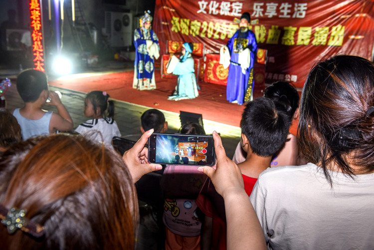 图片默认标题_fororder_6月18日晚，在河北省涿州市“戏曲进乡村”剧团走进码头镇东杨合庄村开展文化惠活动。图为村民用手机记录精彩的戏曲演出。刘永兴 摄