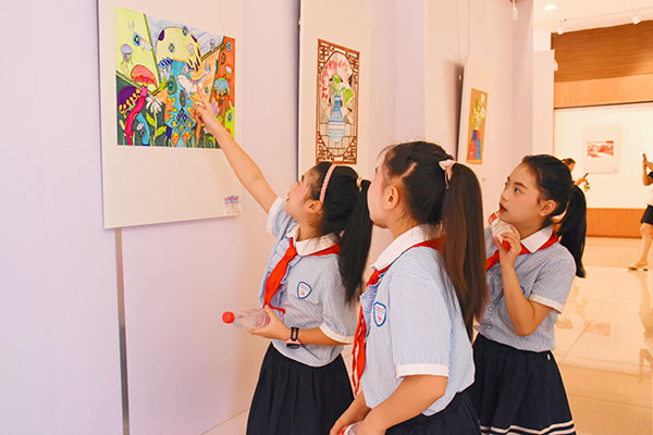 （张）德阳中江：“童心向党 童画六一”少儿美术作品展开幕_fororder_学生在画作前交流