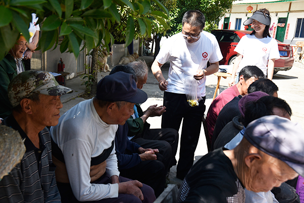 广元：情系休养员开展送温暖 提升群众生活幸福指数_fororder_杨广树为老人们分发糖果
