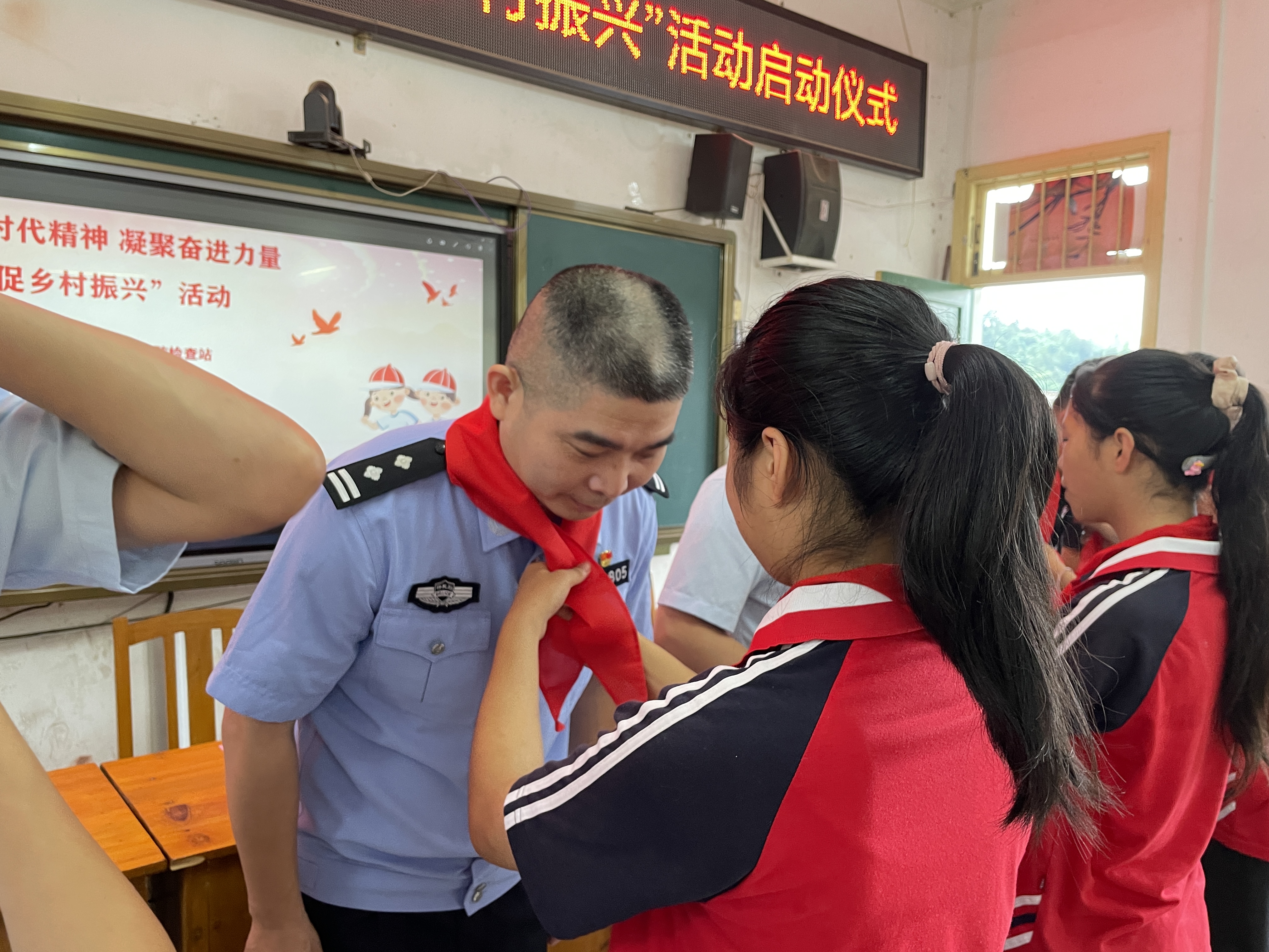 福建漳州出入境边防检查站：携手创建党建帮扶品牌 巩固拓展脱贫攻坚成果_fororder_图为学生代表为民警佩戴红领巾