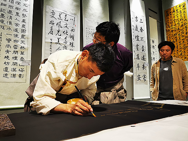 听山歌、逛展会、看民俗、品美食……2023年甘孜州炉霍望果民俗文化活动启幕_fororder_炉霍文博馆举行的书法展上，甘孜本土书法家在创作+图+戴建伟