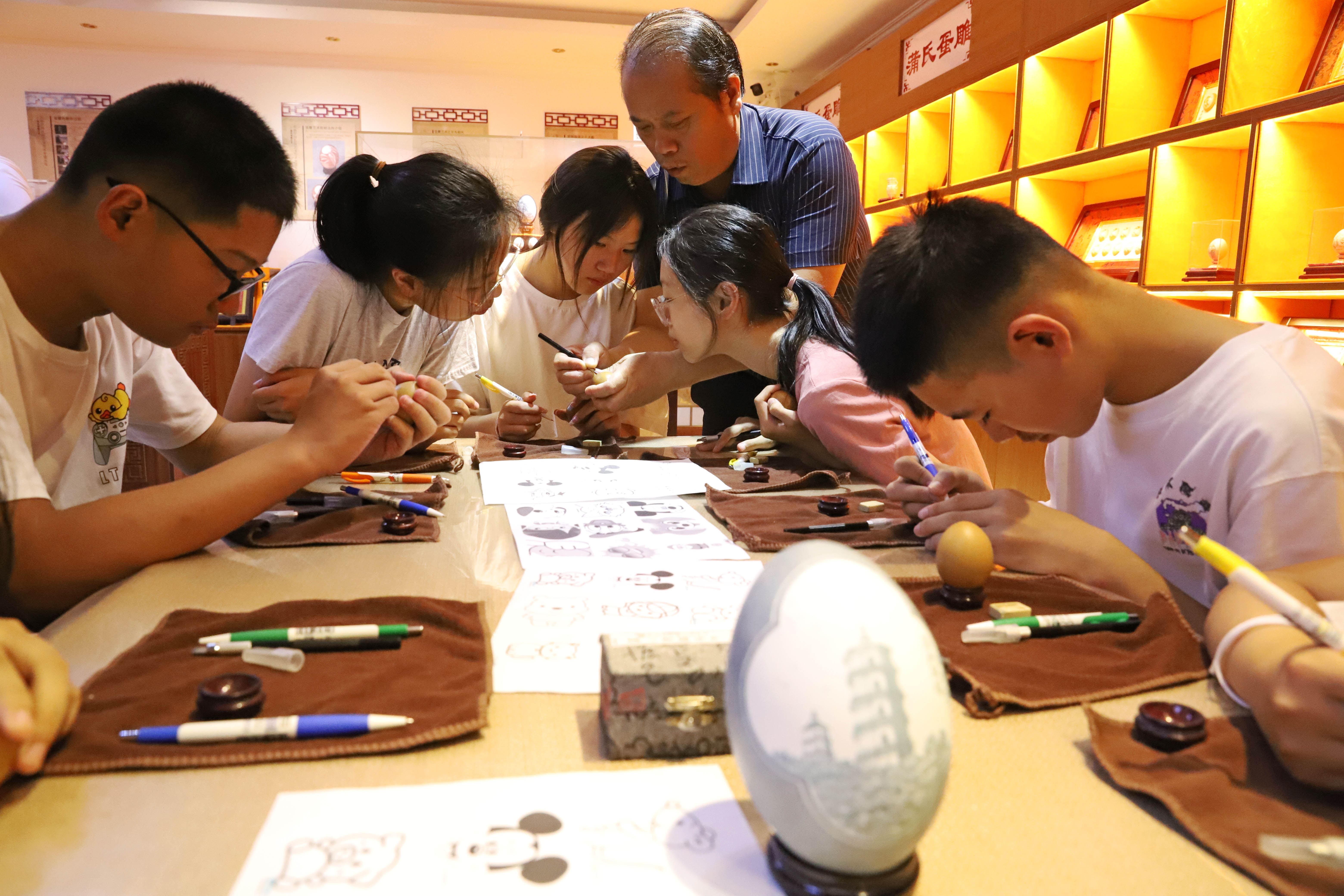 河北涿州：学生们假期生活增添“非遗色”_fororder_7月16日，河北省第六批省级非物质文化遗产项目（蛋雕）代表性传承人蒲德荣为学生们展示雕刻技艺。熊华明摄
