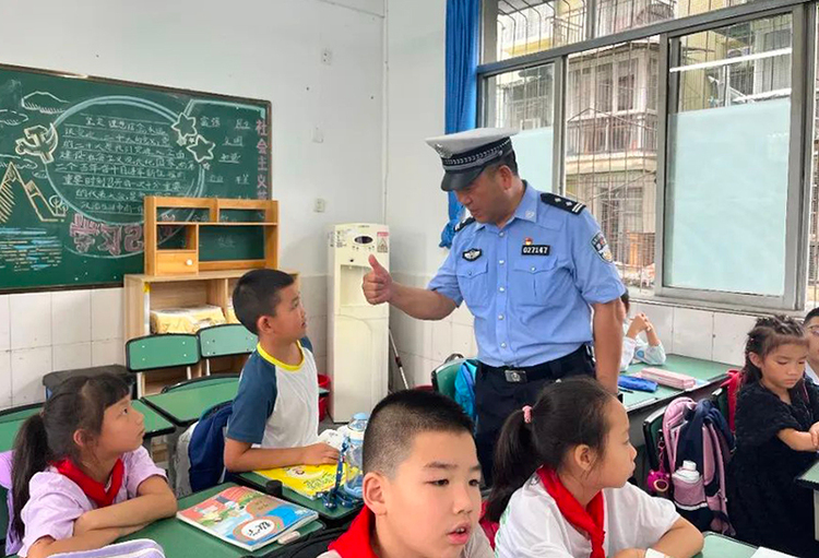 广汉公安站好“护学岗” 撑起“平安伞”_fororder_交警与学生进行互动提问