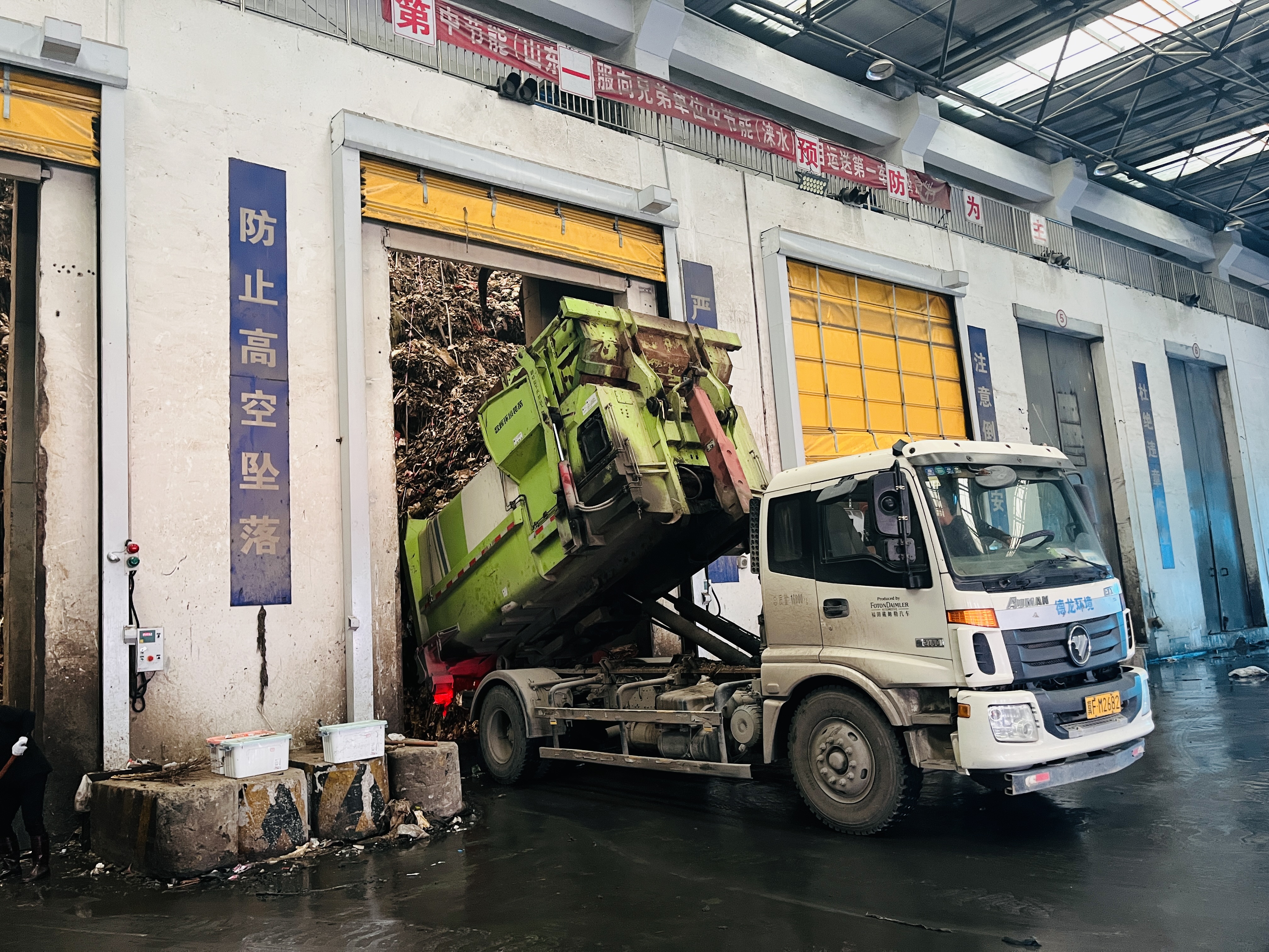 河北涞水：做好灾区垃圾清运 保障民众生产生活_fororder_图为在中节能涞水公司卸料平台，环卫工人正驾驶垃圾转运车将垃圾倾倒进全封闭垃圾仓内。（李金璐 摄）.JPG