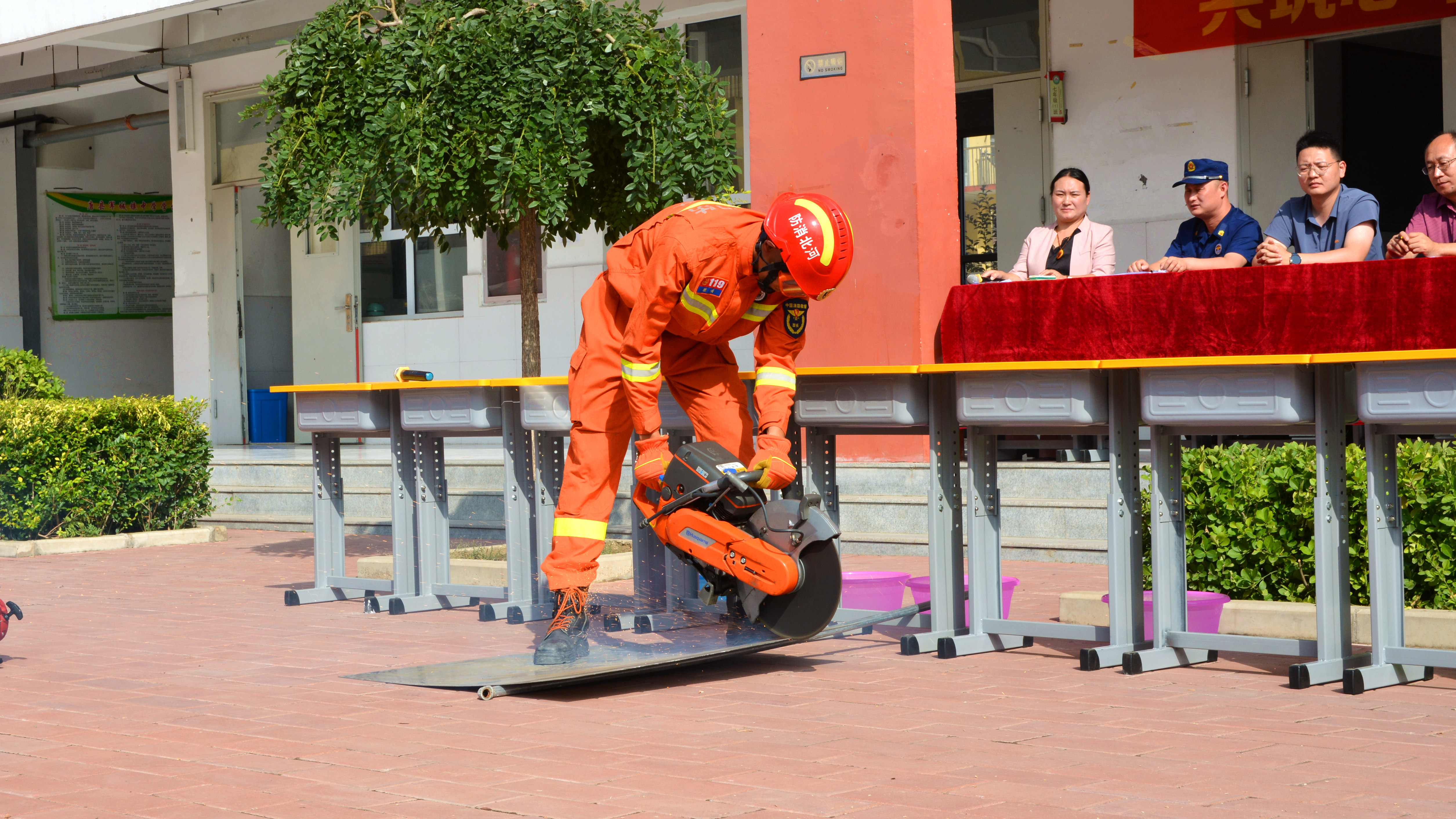 （原创）河北唐县：共筑心中防火墙 搭建生命安全网_fororder_消防员正向学生们演示破拆工具如何使用 (2).JPG