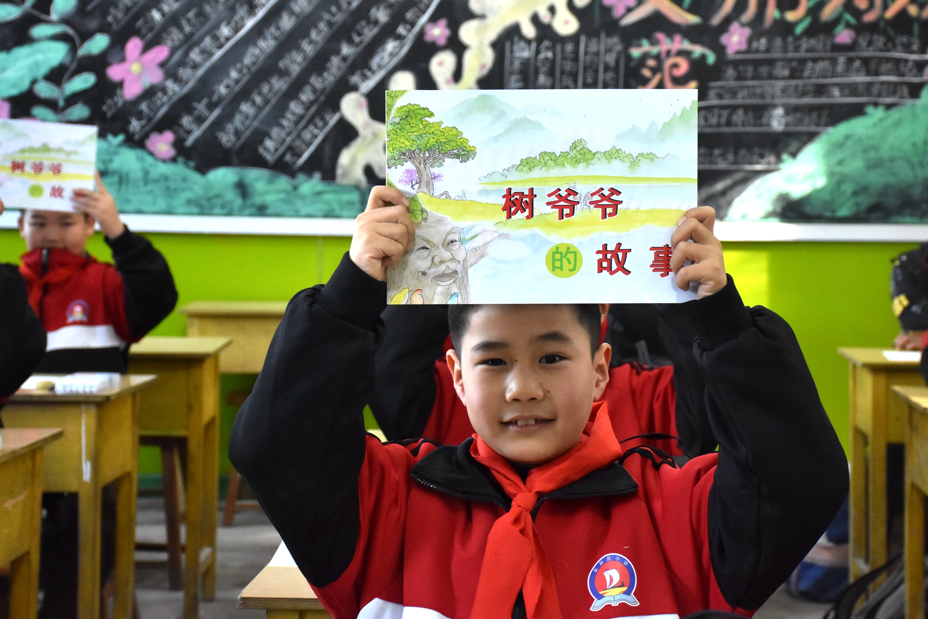 河北清苑：环保宣传进校园 文明理念入童心_fororder_同学们展示环保主题绘本。 赵琪摄.JPG