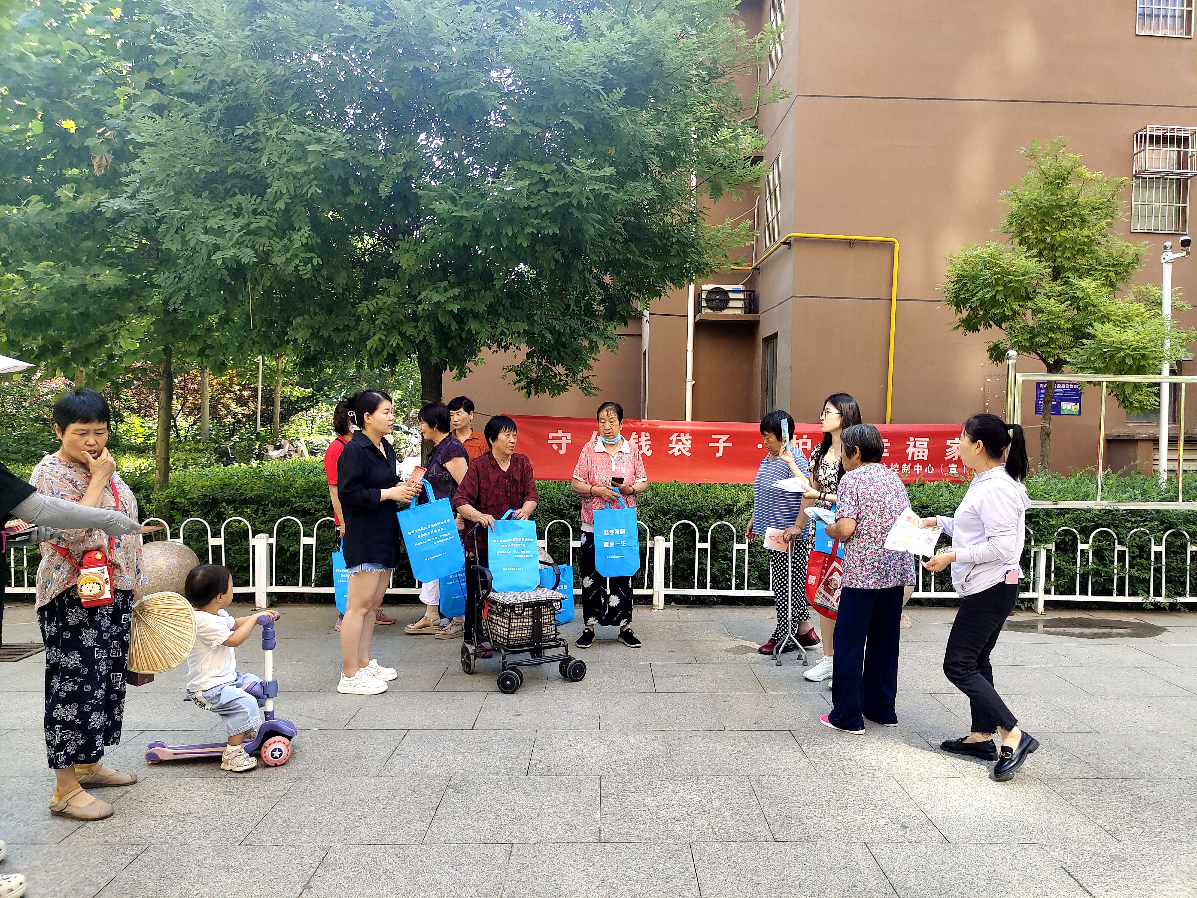 河北唐县：推动非法集资宣传深入人心_fororder_工作人员走进小区开展防范非法集资宣传，发放宣传页
