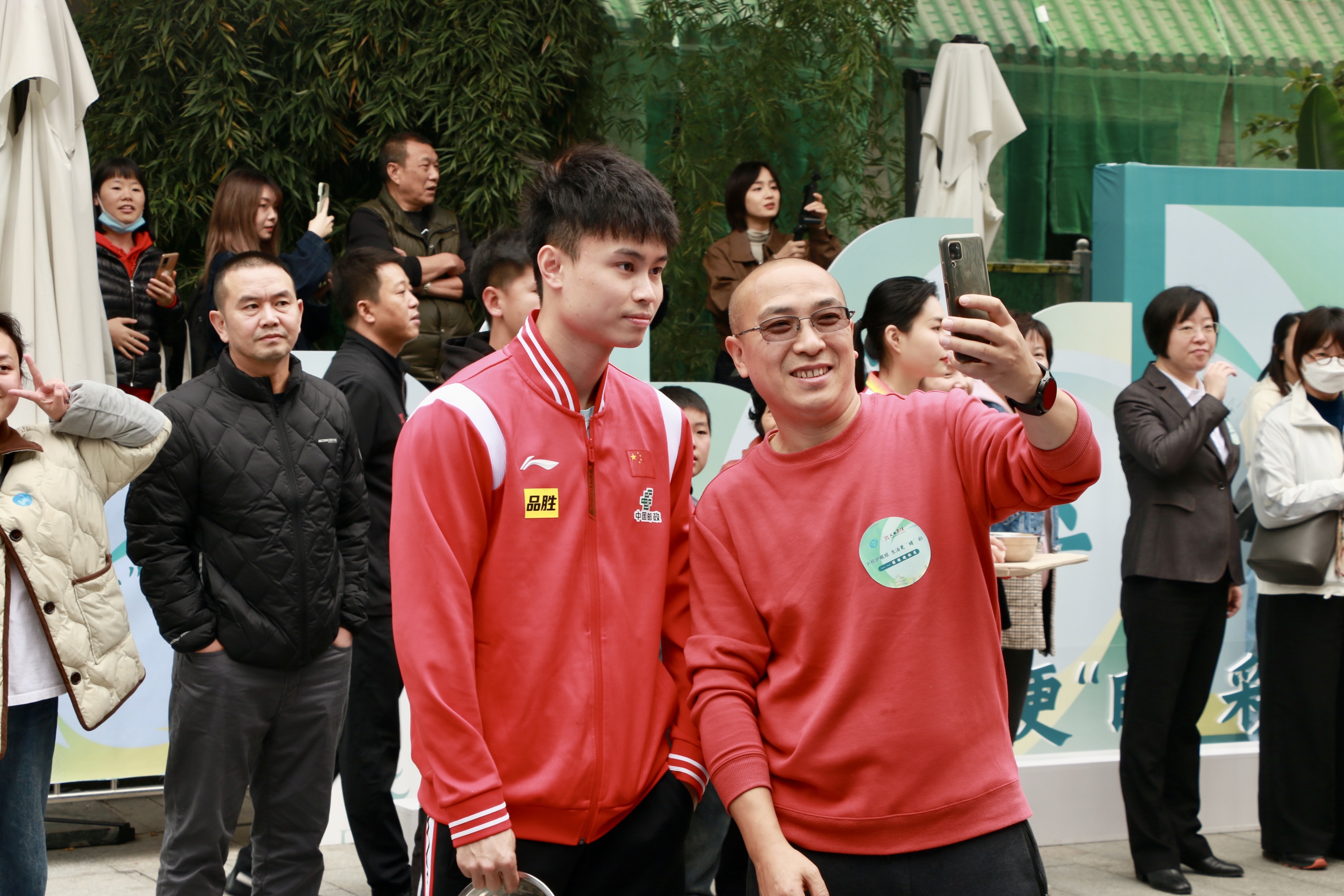 乒乓球国手进社区 感受成都赛事名城的万千气象_fororder_周启豪与居民代表合影留念 摄影 杨雯涵